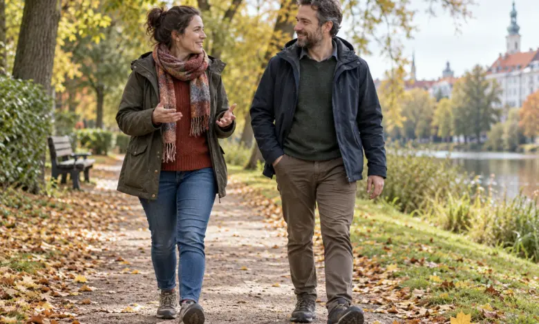 Zwei Erwachsene gehen entspannt auf einem herbstlichen Parkweg spazieren. [Bildinhalt mit KI erstellt]