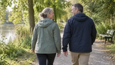 Zwei Erwachsene gehen auf einem baumgesäumten Parkweg spazieren [Bildinhalt mit KI erstellt]