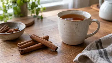 Zimtstangen neben einer Tasse Tee auf einem Holztisch [Bildinhalt mit KI erstellt]